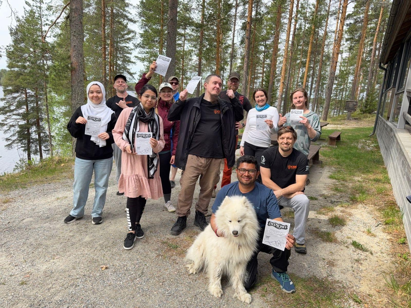 Group of people with a white dog on a forest path by a lake