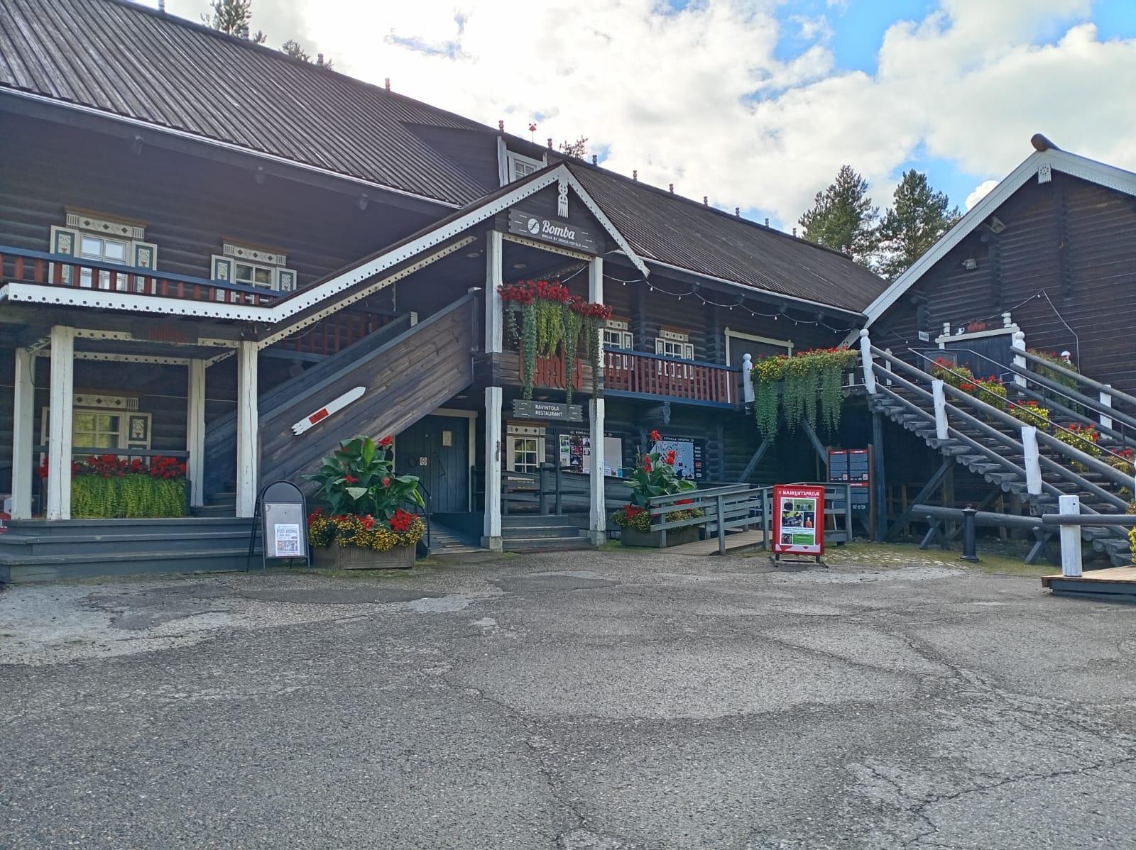 Large log building and courtyard at Bomba